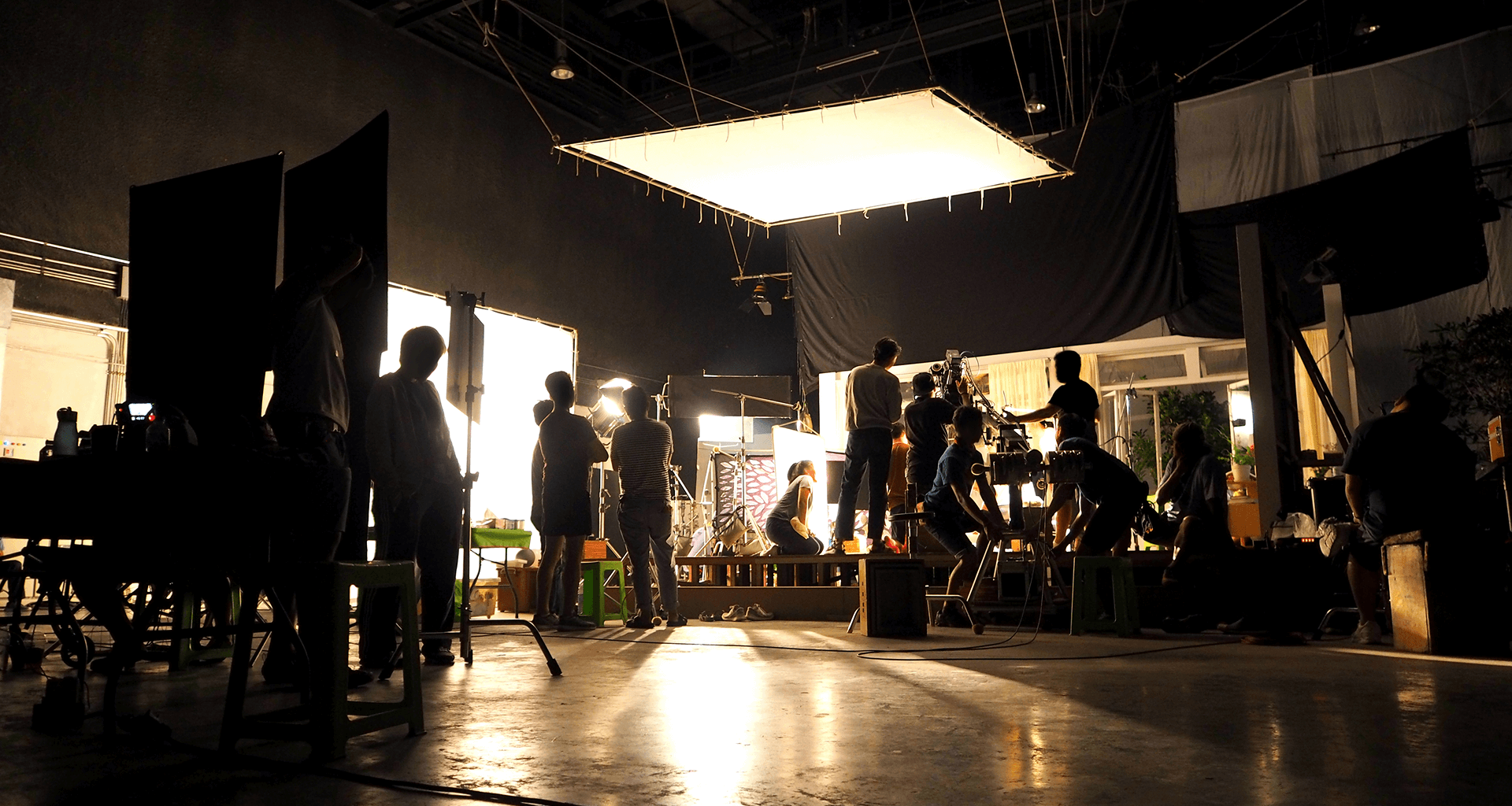 Film crew working on a large warehouse studio set